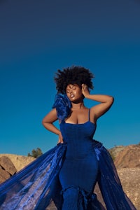 a woman in a blue dress posing in the desert