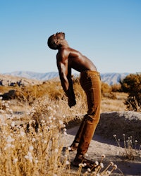 a man standing in the desert with his arms raised