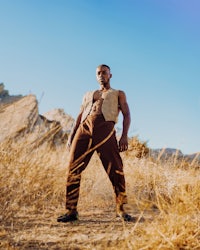 a man is standing in a field of dry grass