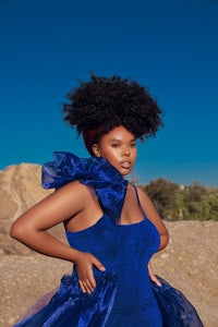 a woman in a blue dress posing in the desert